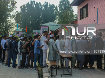 Voters queue to cast their ballots at a polling station during the second phase of assembly elections in Srinagar, Jammu and Kashmir, on Sep...