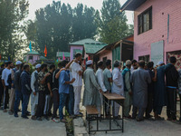 Voters queue to cast their ballots at a polling station during the second phase of assembly elections in Srinagar, Jammu and Kashmir, on Sep...