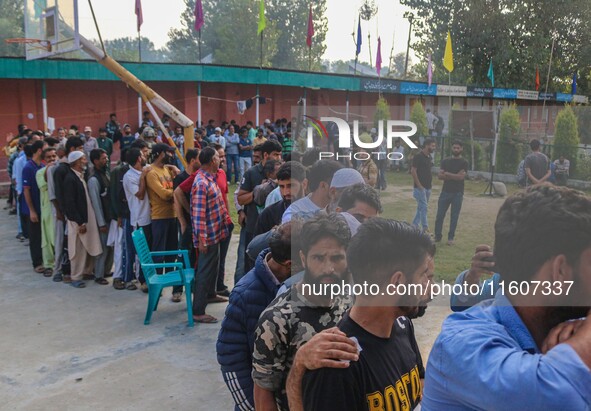 Voters queue to cast their ballots at a polling station during the second phase of assembly elections in Srinagar, Jammu and Kashmir, on Sep...