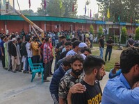 Voters queue to cast their ballots at a polling station during the second phase of assembly elections in Srinagar, Jammu and Kashmir, on Sep...