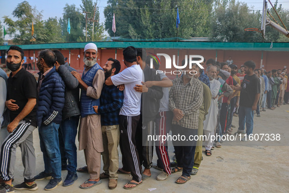 Voters queue to cast their ballots at a polling station during the second phase of assembly elections in Srinagar, Jammu and Kashmir, on Sep...