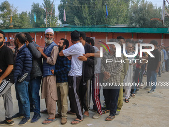 Voters queue to cast their ballots at a polling station during the second phase of assembly elections in Srinagar, Jammu and Kashmir, on Sep...