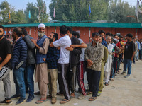 Voters queue to cast their ballots at a polling station during the second phase of assembly elections in Srinagar, Jammu and Kashmir, on Sep...