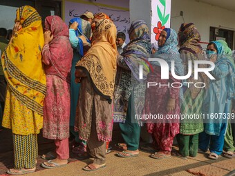 Women voters queue to cast their ballots at a polling station during the second phase of assembly elections in Srinagar, Jammu and Kashmir,...