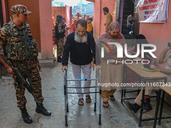 A handicapped man arrives to cast his ballot at a polling station during the second phase of assembly elections in Srinagar, Jammu and Kashm...