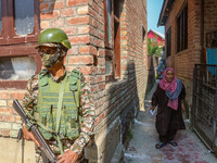 An elderly woman arrives to cast her ballot at a polling station during the second phase of assembly elections in Srinagar, Jammu and Kashmi...