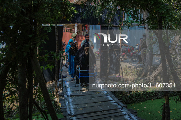 A handicapped woman arrives to cast her ballot at a polling station during the second phase of assembly elections in Srinagar, Jammu and Kas...