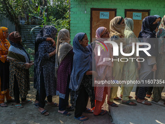 Women voters queue to cast their ballots at a polling station during the second phase of assembly elections in Srinagar, Jammu and Kashmir,...