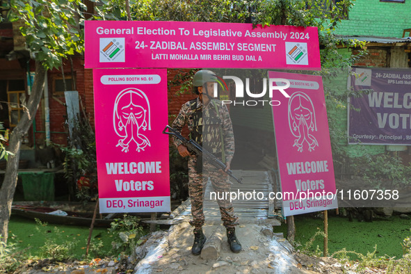 An Indian paramilitary soldier stands guard outside a polling station during the second phase of assembly elections in Srinagar, Jammu and K...