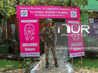 An Indian paramilitary soldier stands guard outside a polling station during the second phase of assembly elections in Srinagar, Jammu and K...