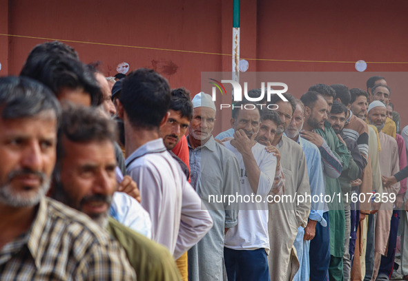 Voters queue to cast their ballots at a polling station during the second phase of assembly elections in Srinagar, Jammu and Kashmir, on Sep...