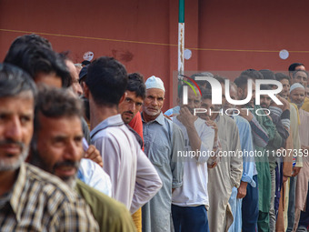 Voters queue to cast their ballots at a polling station during the second phase of assembly elections in Srinagar, Jammu and Kashmir, on Sep...