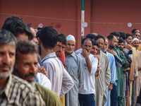 Voters queue to cast their ballots at a polling station during the second phase of assembly elections in Srinagar, Jammu and Kashmir, on Sep...