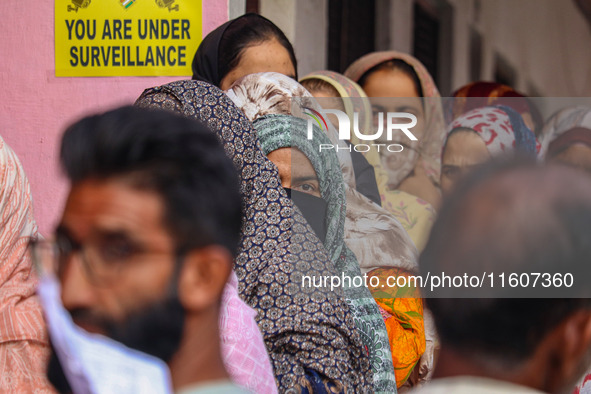 Voters queue to cast their ballots at a polling station during the second phase of assembly elections in Srinagar, Jammu and Kashmir, on Sep...