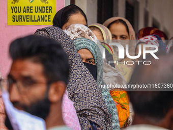 Voters queue to cast their ballots at a polling station during the second phase of assembly elections in Srinagar, Jammu and Kashmir, on Sep...