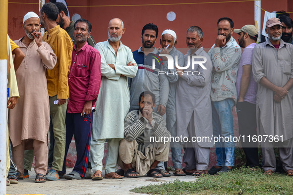 Voters queue to cast their ballots at a polling station during the second phase of assembly elections in Srinagar, Jammu and Kashmir, on Sep...