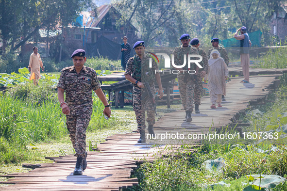 Indian security personnel walk in the interiors of Dal Lake during the second phase of assembly elections in Srinagar, Jammu and Kashmir, on...