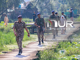 Indian security personnel walk in the interiors of Dal Lake during the second phase of assembly elections in Srinagar, Jammu and Kashmir, on...