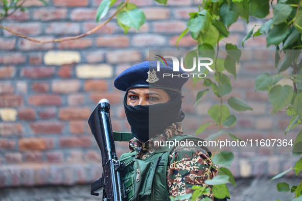 An Indian paramilitary woman soldier stands guard outside a polling station during the second phase of assembly elections in Srinagar, Jammu...