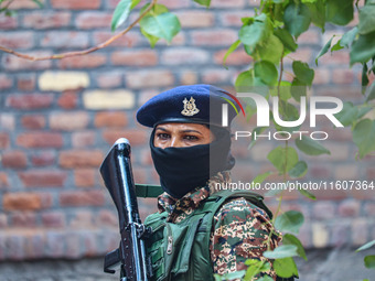 An Indian paramilitary woman soldier stands guard outside a polling station during the second phase of assembly elections in Srinagar, Jammu...