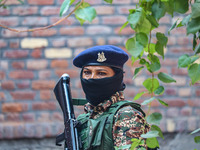 An Indian paramilitary woman soldier stands guard outside a polling station during the second phase of assembly elections in Srinagar, Jammu...