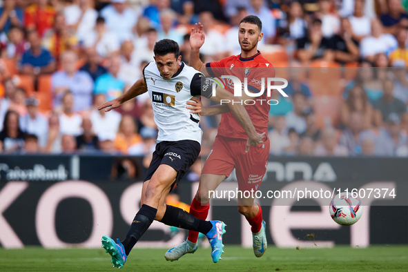 Cesar Tarrega of Valencia CF competes for the ball with Raul of CA Osasuna during the LaLiga EA Sports match between Valencia CF and CA Osas...