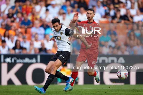 Cesar Tarrega of Valencia CF competes for the ball with Raul of CA Osasuna during the LaLiga EA Sports match between Valencia CF and CA Osas...