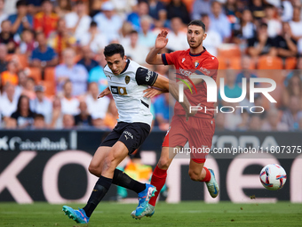 Cesar Tarrega of Valencia CF competes for the ball with Raul of CA Osasuna during the LaLiga EA Sports match between Valencia CF and CA Osas...