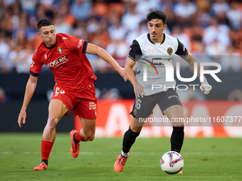 Diego Lopez of Valencia CF competes for the ball with Abel Bretones of CA Osasuna during the LaLiga EA Sports match between Valencia CF and...