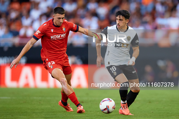 Diego Lopez of Valencia CF competes for the ball with Abel Bretones of CA Osasuna during the LaLiga EA Sports match between Valencia CF and...