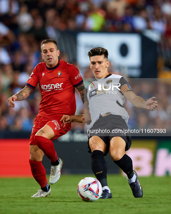 Pepelu of Valencia CF competes for the ball with Ruben Pena of CA Osasuna during the LaLiga EA Sports match between Valencia CF and CA Osasu...