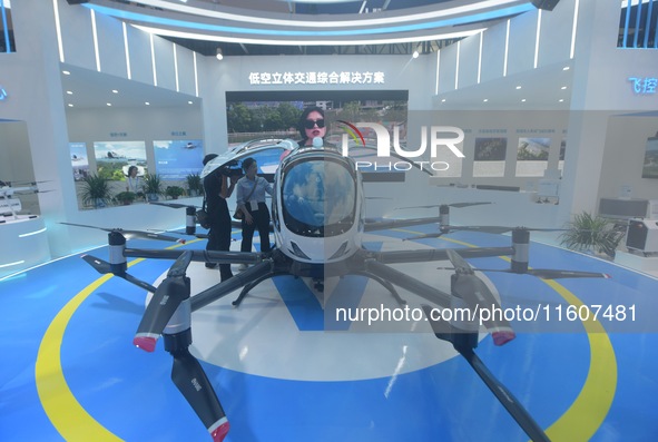 Viewers watch Yihang's "flying car" electric vertical takeoff and landing aircraft (eVTOL) at the Global Digital Trade Expo in Hangzhou, Chi...