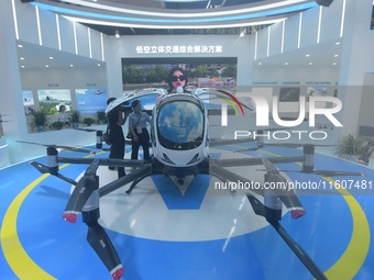 Viewers watch Yihang's "flying car" electric vertical takeoff and landing aircraft (eVTOL) at the Global Digital Trade Expo in Hangzhou, Chi...