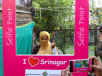 A woman voter poses for a picture after casting her vote at a polling station during the second phase of assembly elections in Srinagar, Ind...