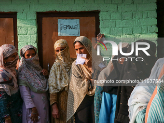 People stand in line to cast their vote at a polling station during the second phase of assembly elections in Srinagar, Indian Administered...