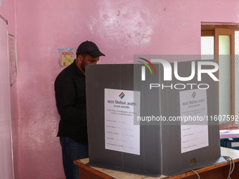 A man casts his vote at a polling station during the second phase of assembly elections in Srinagar, Indian Administered Kashmir, on Septemb...