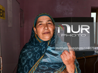 A woman voter poses for a picture after casting her vote at a polling station during the second phase of assembly elections in Srinagar, Ind...