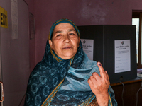 A woman voter poses for a picture after casting her vote at a polling station during the second phase of assembly elections in Srinagar, Ind...