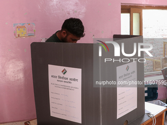 A man casts his vote at a polling station during the second phase of assembly elections in Srinagar, Indian Administered Kashmir, on Septemb...