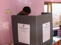 A man casts his vote at a polling station during the second phase of assembly elections in Srinagar, Indian Administered Kashmir, on Septemb...