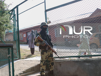 An Indian paramilitary trooper stands alert at a polling station during the second phase of assembly elections in Srinagar, India, on Septem...