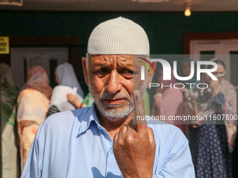 A man poses for a picture after casting his vote at a polling station during the second phase of assembly elections in Srinagar, Indian Admi...