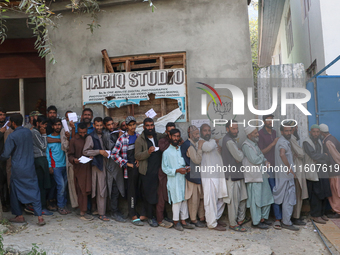 People stand in line to cast their vote at a polling station during the second phase of assembly elections in Srinagar, Indian Administered...