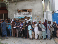 People stand in line to cast their vote at a polling station during the second phase of assembly elections in Srinagar, Indian Administered...