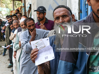 People stand in line to cast their vote at a polling station during the second phase of assembly elections in Srinagar, Indian Administered...