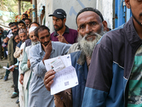 People stand in line to cast their vote at a polling station during the second phase of assembly elections in Srinagar, Indian Administered...