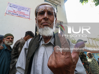 A Kashmiri man shows his inked finger after casting his vote at a polling station during the second phase of assembly elections in Srinagar,...