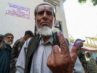 A Kashmiri man shows his inked finger after casting his vote at a polling station during the second phase of assembly elections in Srinagar,...