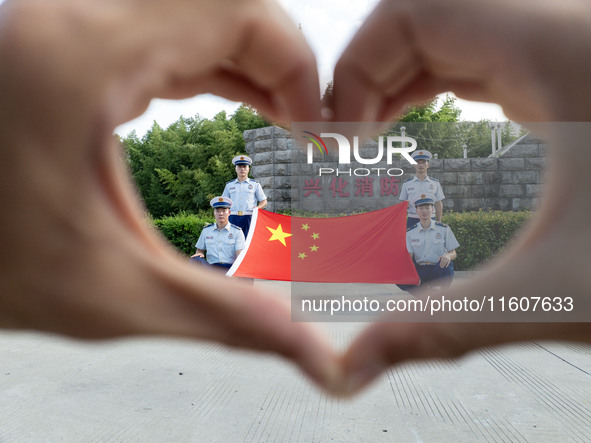 Firefighters pose for a photo with the national flag at the Fire and Rescue Brigade in Xinghua, China, on September 25, 2024. 