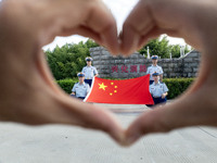 Firefighters pose for a photo with the national flag at the Fire and Rescue Brigade in Xinghua, China, on September 25, 2024. (